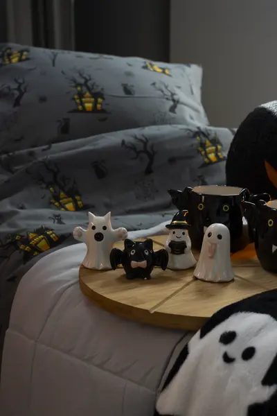 Halloween-somistus makuuhuoneeseen: tarjottimelle asetellut haamu-, lepakko- ja kurpitsakoristeet.