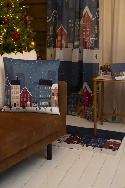 Townhouse-kuosinen koristetyyny, verho ja matto luovat yhtenäisen talvisen sisustuskokonaisuuden olohuoneeseen.